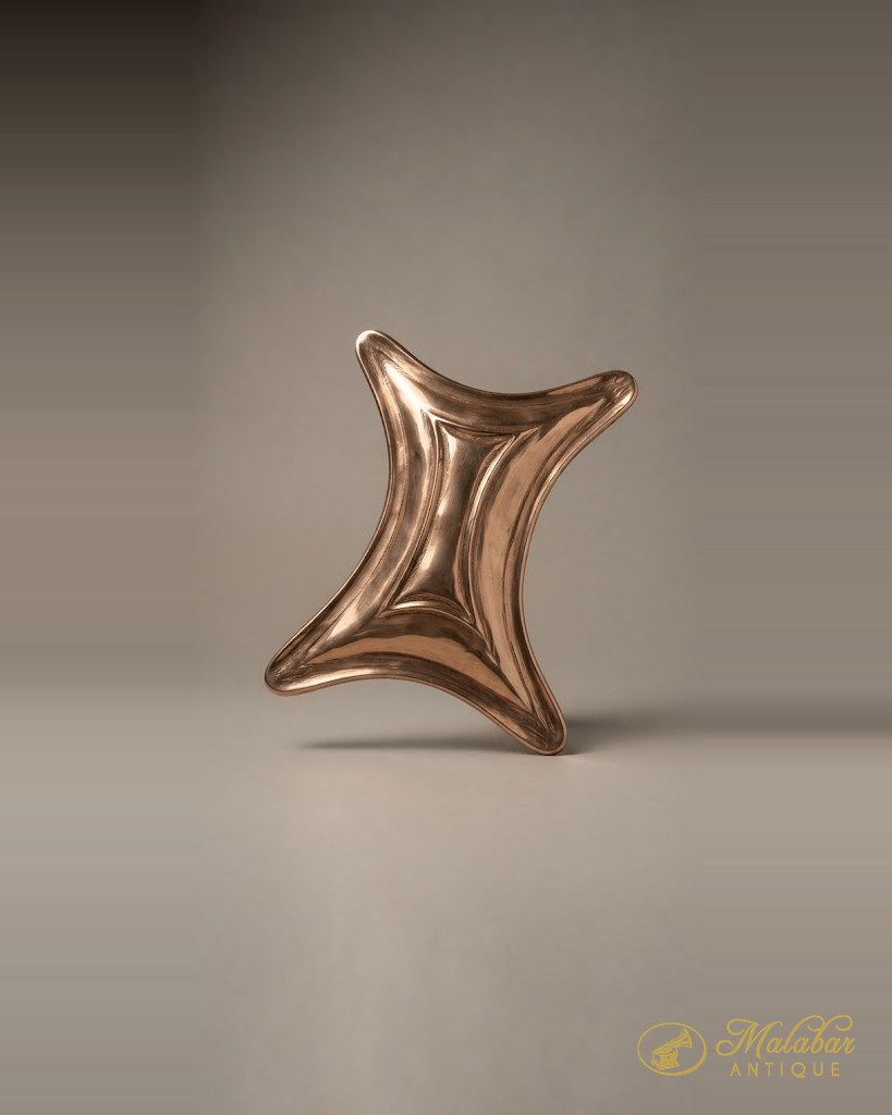 Curved copper object with a polished surface and flared ends.