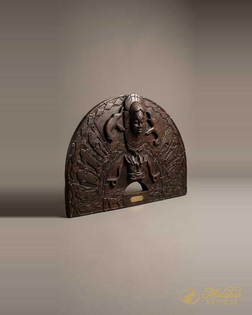 Arch-topped plaque cast in dark metal with a crowned central figure in high relief, flanked by attendant panels and a small brass name plate.