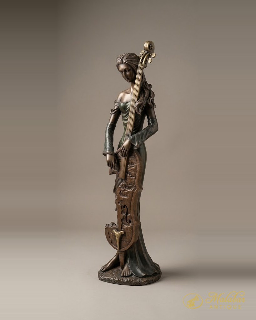 Slender cast figure of a woman in draped dress, dark patinated finish.