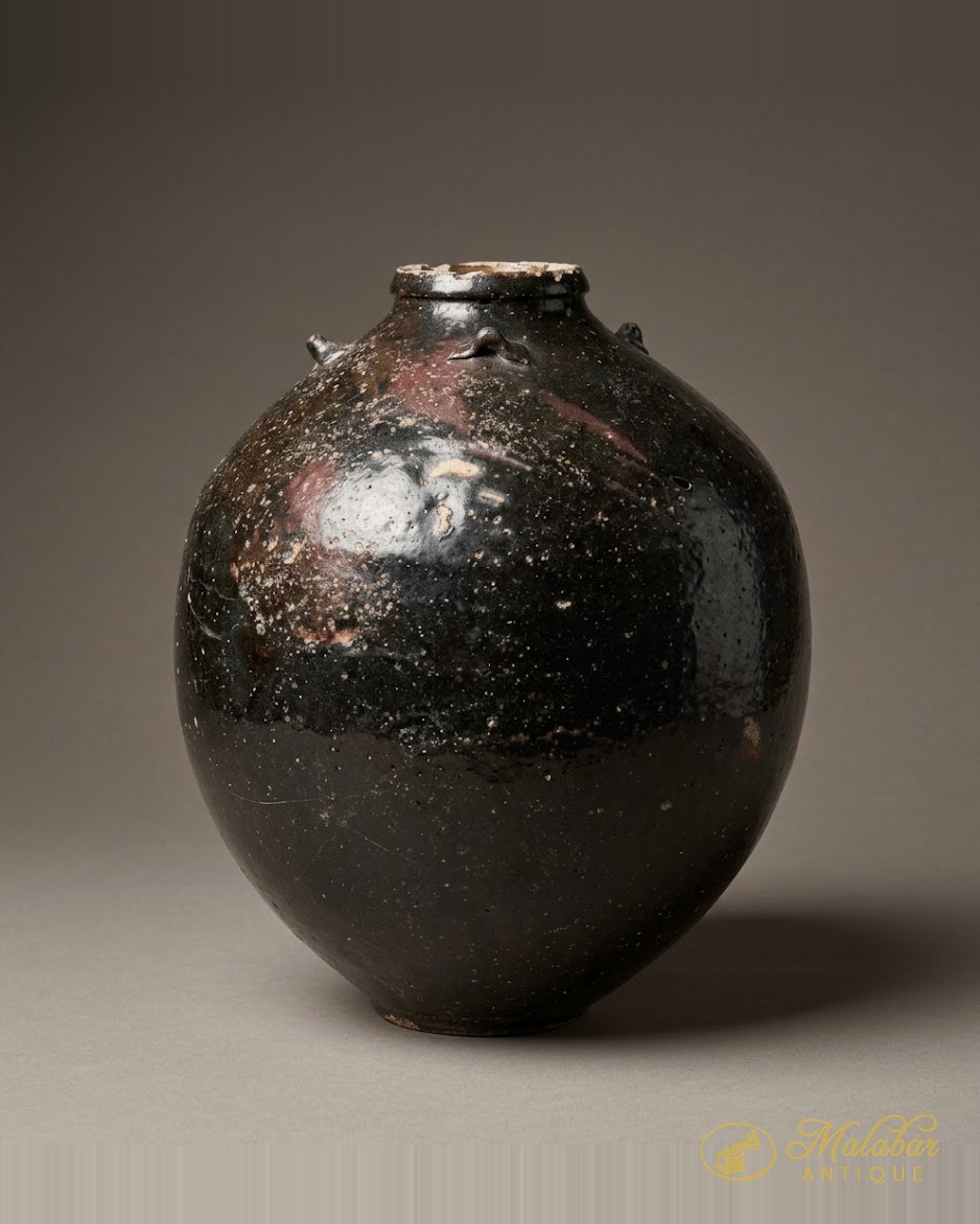 Rounded storage jar in a dark near-black glaze, chipped at the rim.