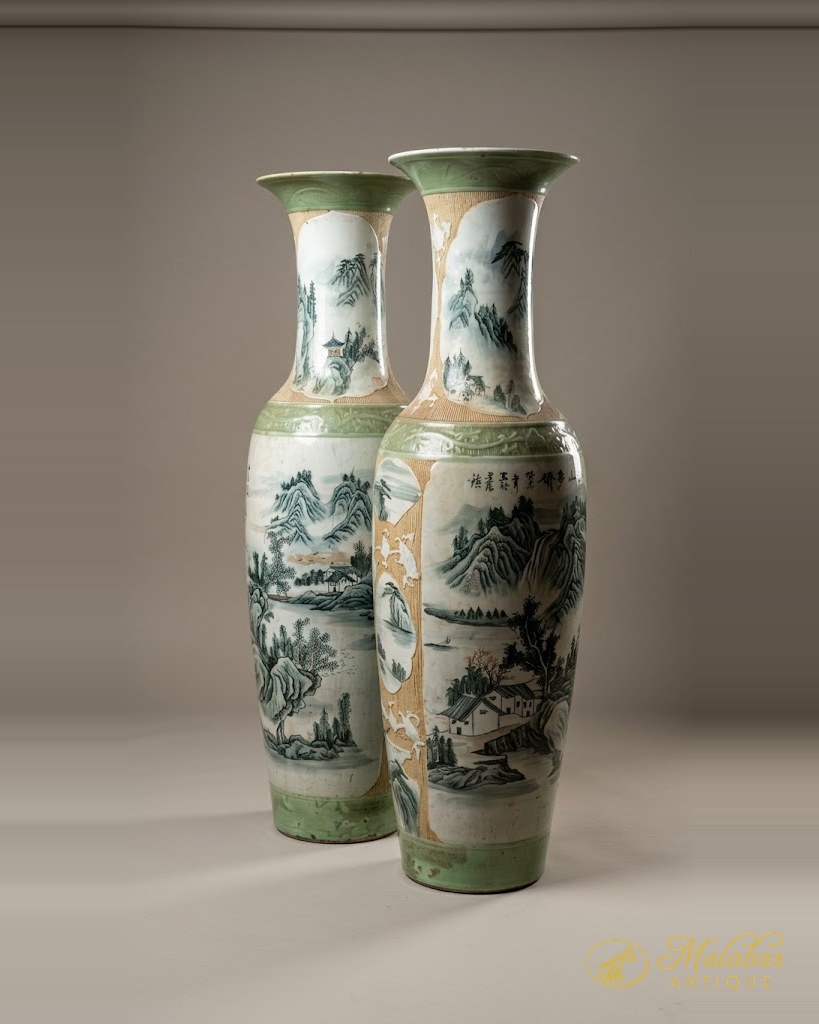 Two tall baluster vases painted with landscape panels in green and rust.