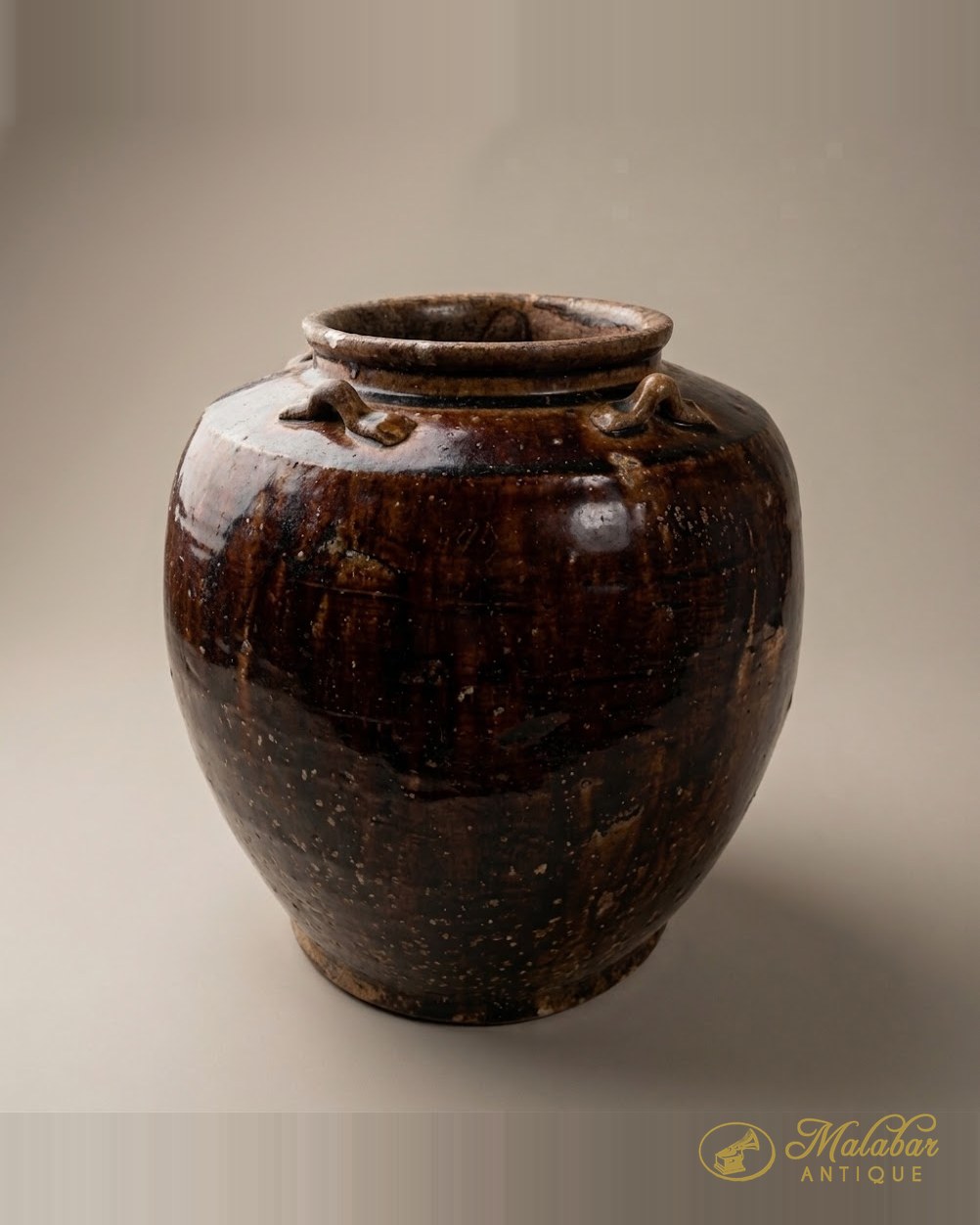 Ovoid storage jar with lug handles in a treacle-brown glaze.