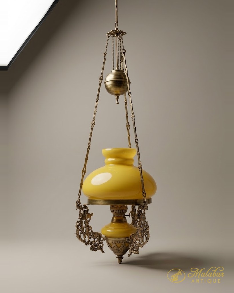 Brass hanging oil lamp with a yellow opaline glass shade and font, pierced scroll galleries and a counterweight on chains.