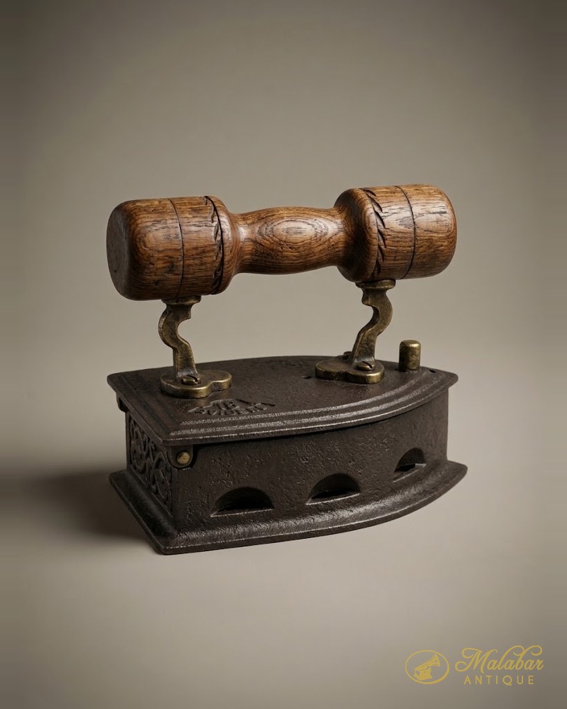 Cast iron charcoal box iron with barrel-turned wooden grips and brass fittings.