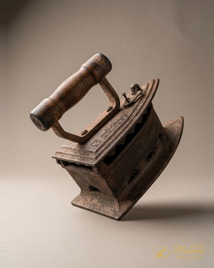 Cast iron charcoal box iron with a smooth turned wooden grip and pierced vents.