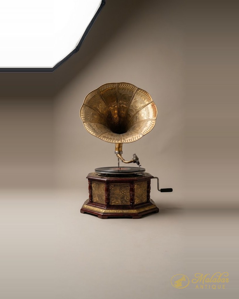 Wind-up gramophone with a brass horn on a hexagonal case.