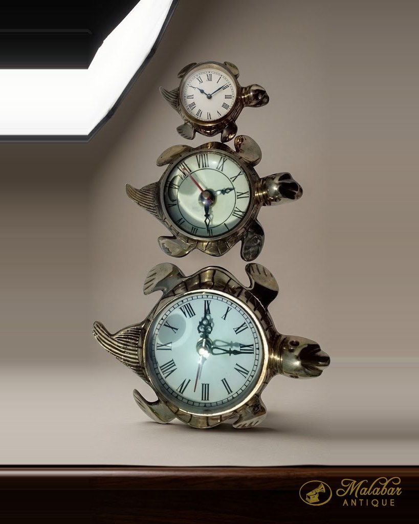 Three small clocks cased as fish and turtles in chromed metal.