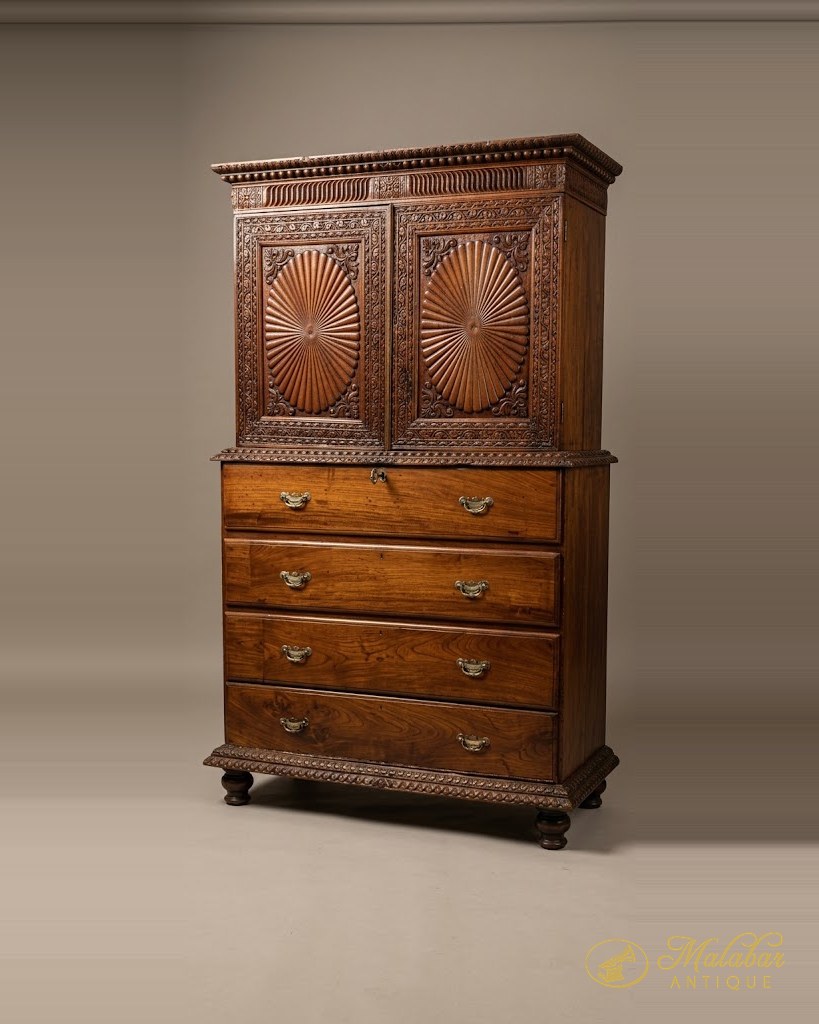 Two-part rosewood cabinet: upper doors carved with sunburst fan medallions over four graduated drawers with brass bail handles, on bun feet.