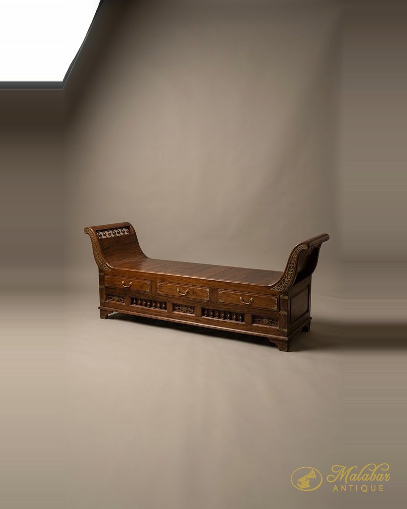 Teak daybed with scrolled ends and pierced side panels.