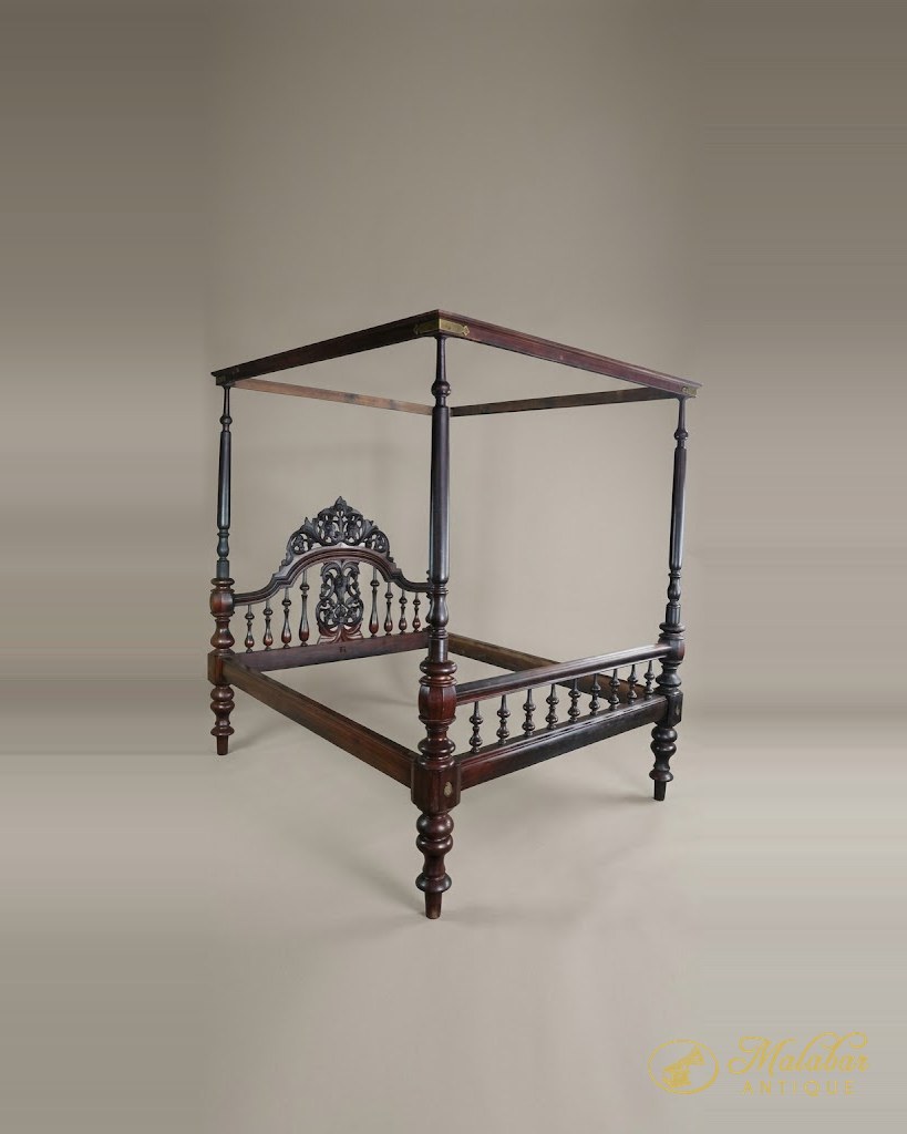 Four-poster bed with turned posts and a pierced carved headboard.
