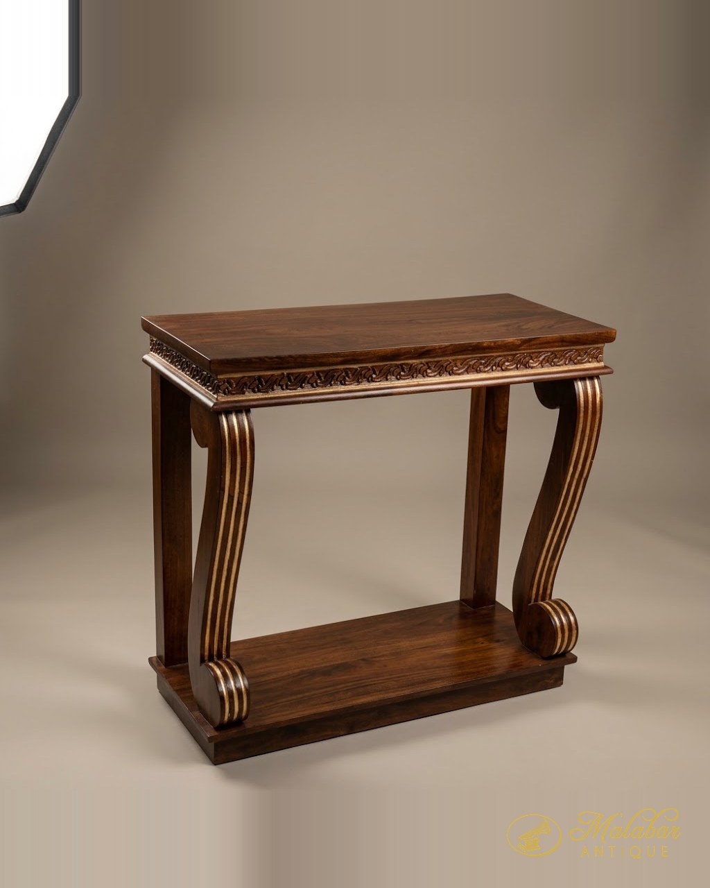 Rosewood console with a carved frieze and heavy scrolled supports.