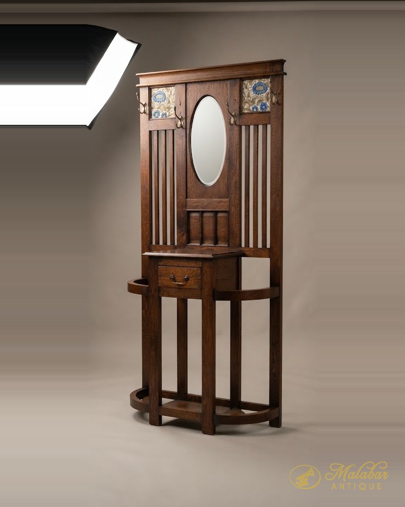 Hall stand with a bevelled oval mirror, tile panels and a small drawer over an open base.