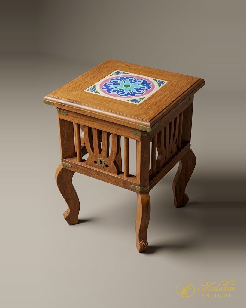 Square teak side table with a painted tile top and pierced apron.