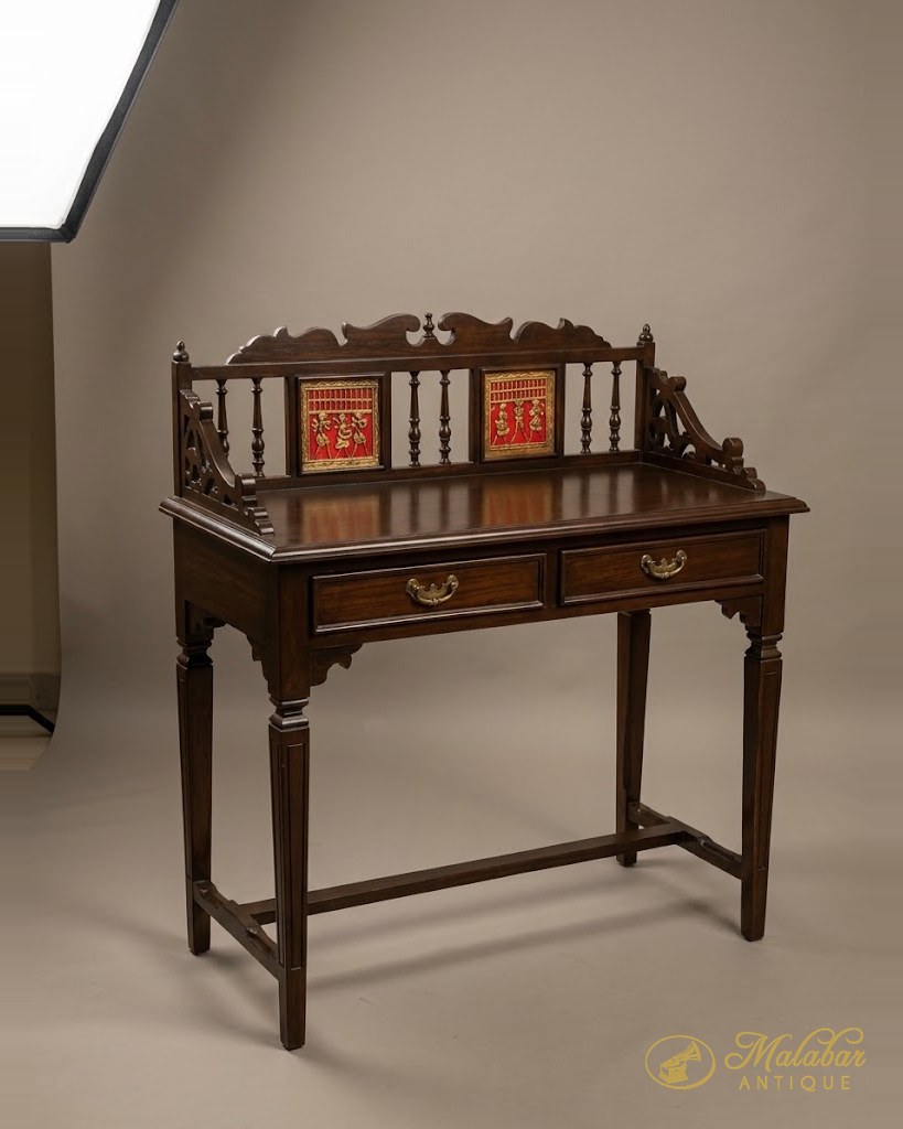 Teak writing desk with a pierced gallery back set with painted tiles, two drawers and turned legs.