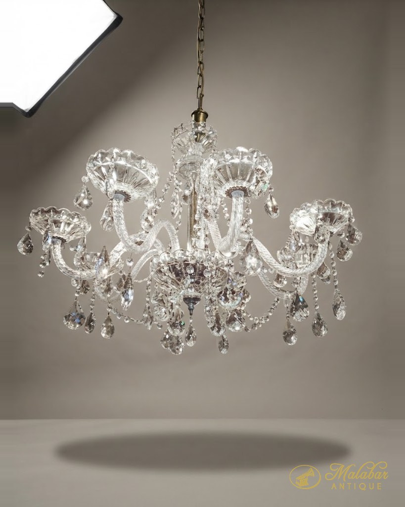Multi-arm chandelier hung with cut crystal drops and scrolled glass arms.