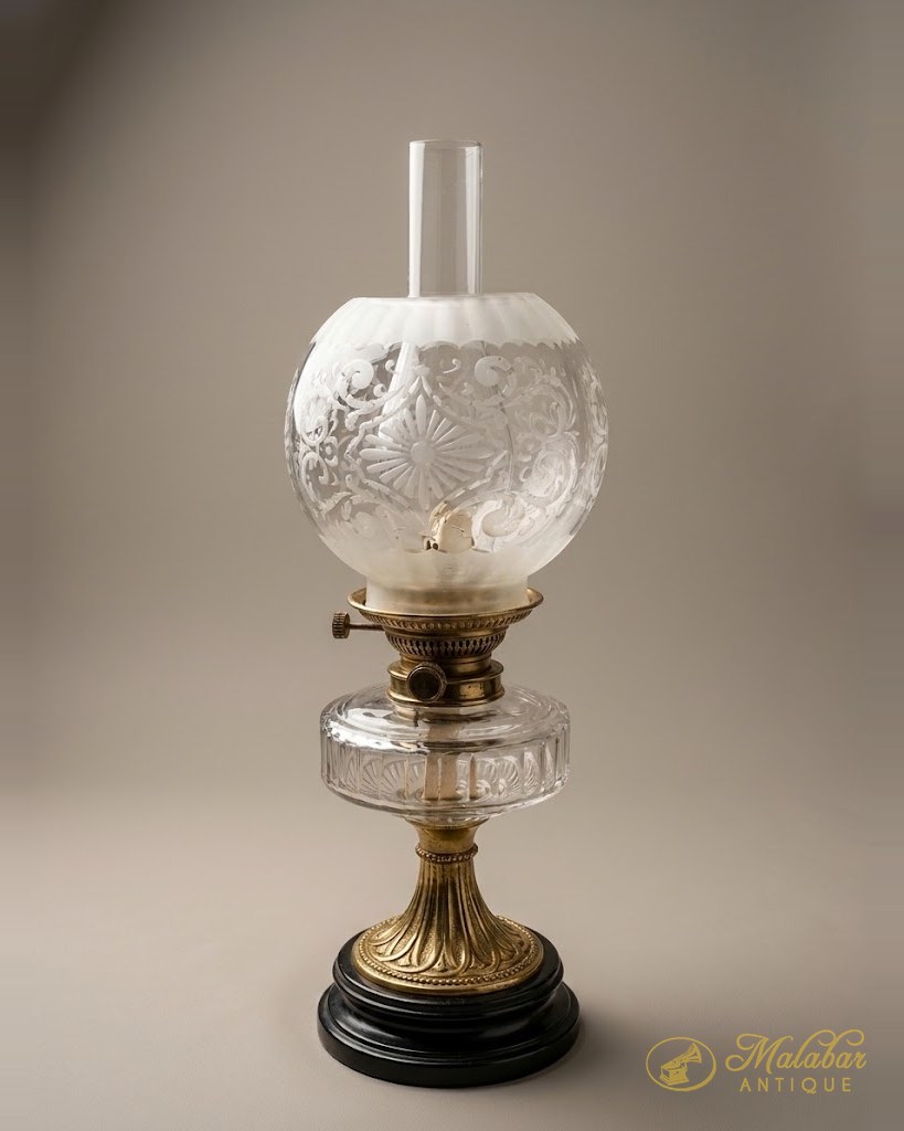 Kerosene lamp with a cut glass reservoir and frosted etched shade.